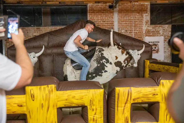 Guest riding a mechanical bull at a warehouse birthday party