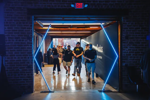Corporate crowd under blue uplighting across the main floor