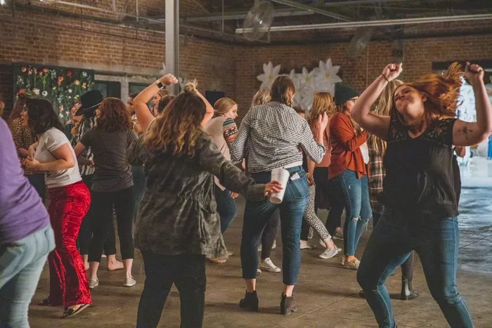 Friends dancing in a crowd on the warehouse floor
