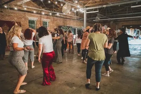 Guests filling the dance floor under string lights