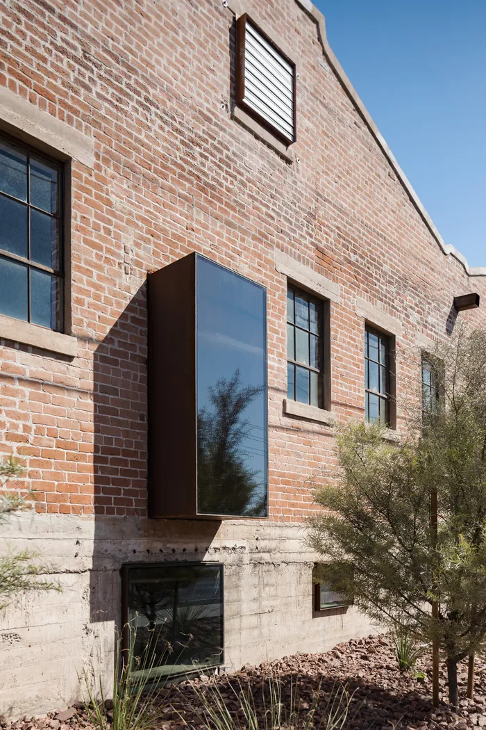 Original red brick facade with restored steel-framed windows