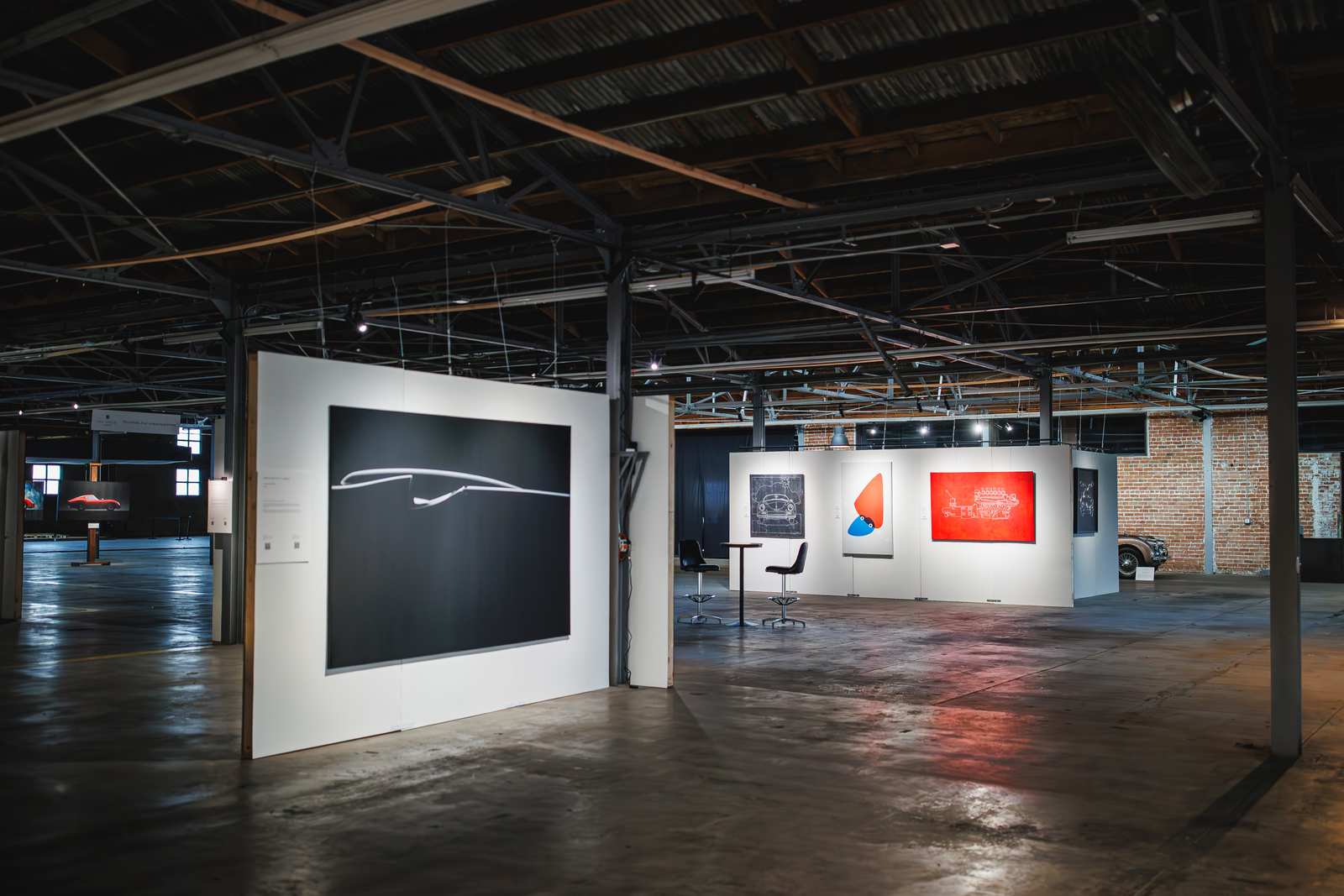 Gallery walls and artwork staged across the warehouse floor for an evening event