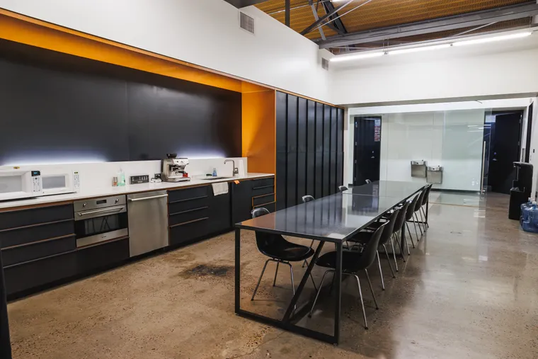 The Hospitality Room — private kitchen-style suite with long table, chairs, refrigerator, and microwave