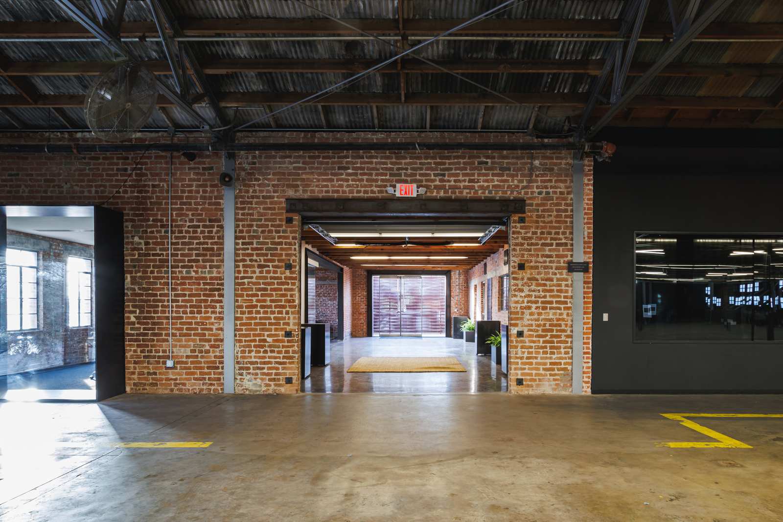Restored brick corridor and doorway with warm light — the small-events side of the building