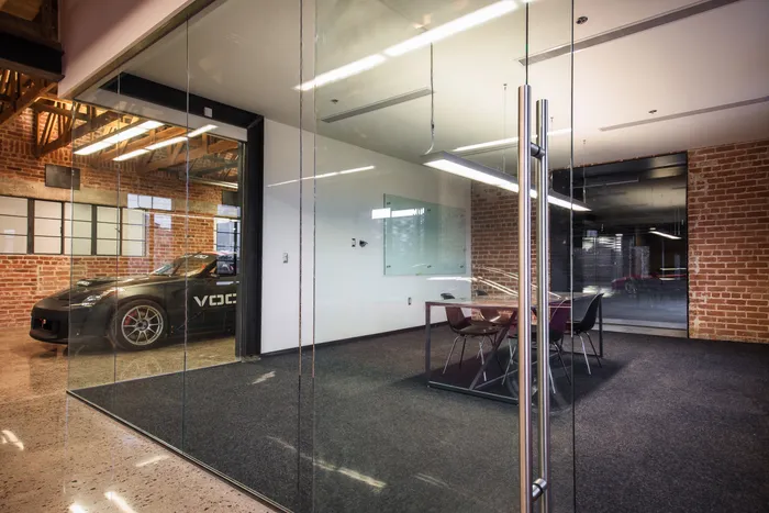 The Conference Room — glass-walled meeting room seating about ten