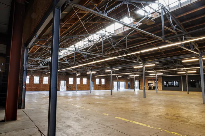 The Majestic — main event space with original brick walls, timber trusses, and doghouse skylights
