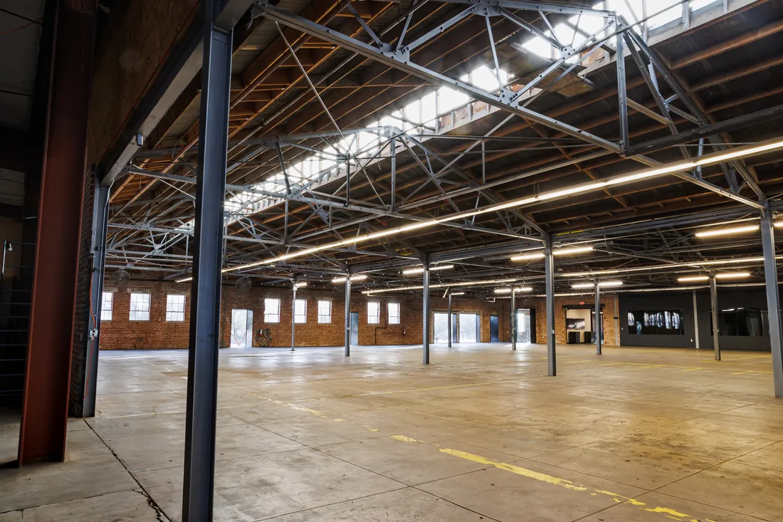 The Majestic — original brick, timber trusses, and doghouse skylights over the main event floor