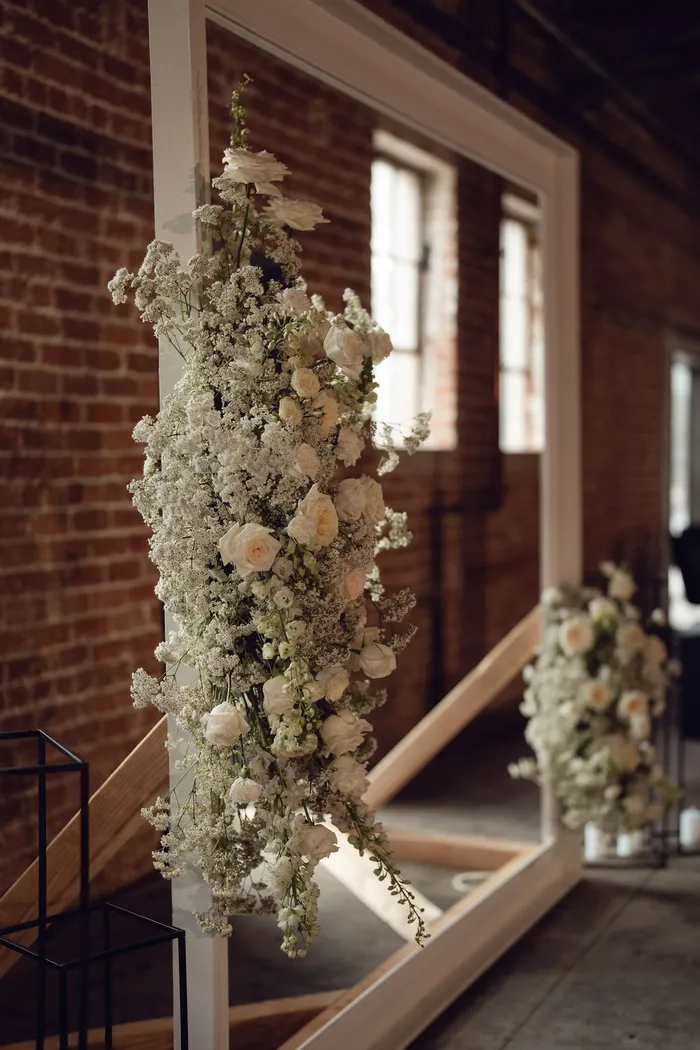 White floral installation climbing a freestanding frame