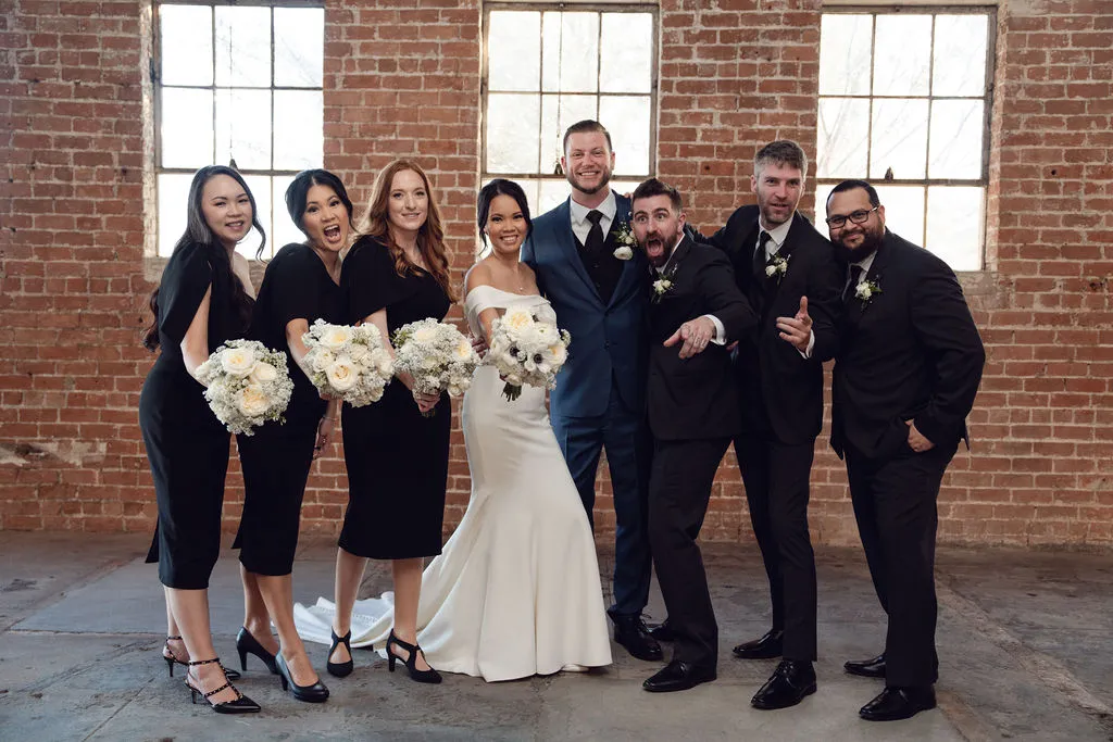 Wedding party in black and white beneath the warehouse windows